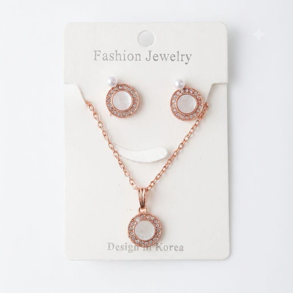 Rose gold-tone fashion jewelry set includes a circular moon pendant necklace and matching stud