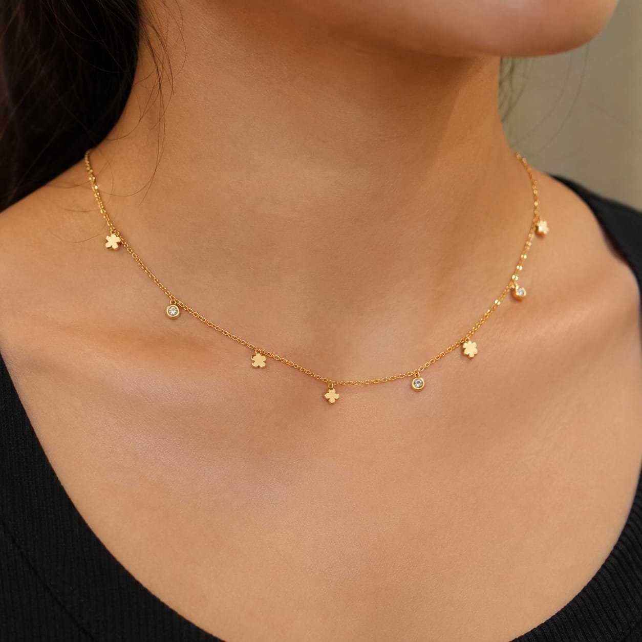 Dainty gold-toned station charm choker necklace featuring alternating micro-charms dangling along a delicate link chain.