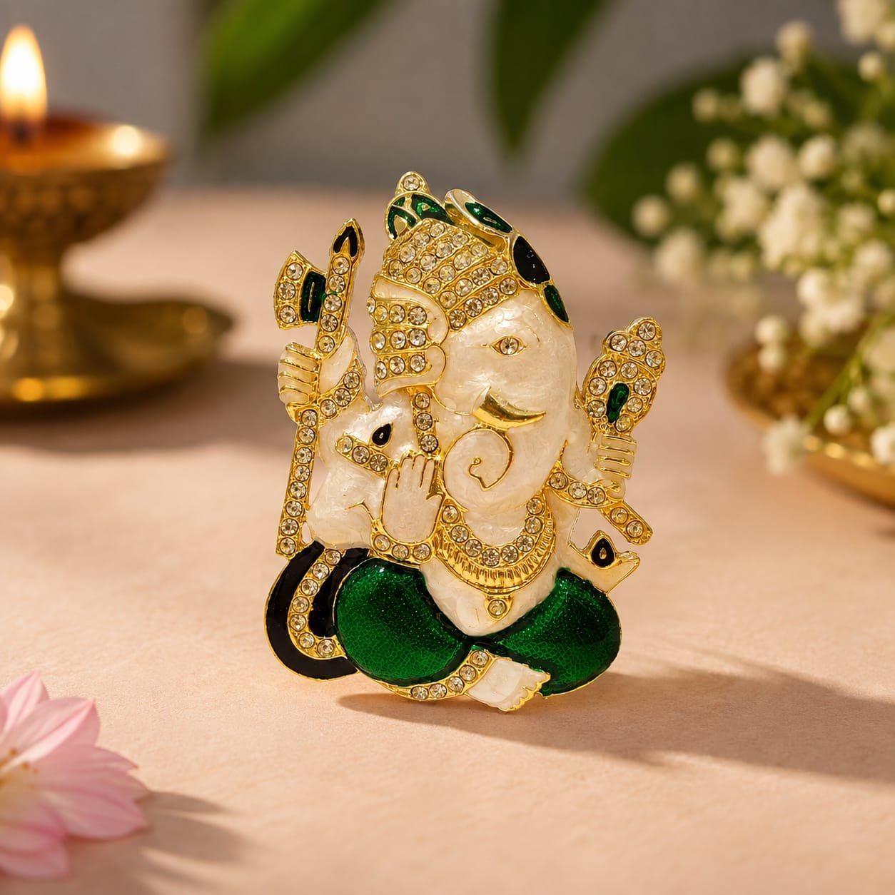 Decorative Lord Ganesha showpiece features a white marble-finish body embellished with sparkling crystal stones and vibrant green.